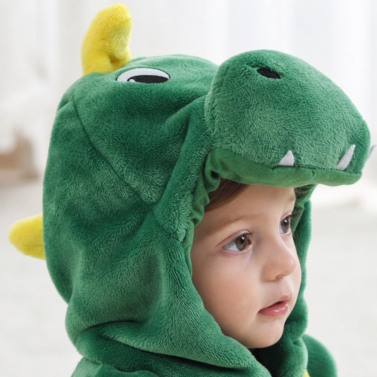 Close-up of the green dragon hood with felt teeth and yellow horns
